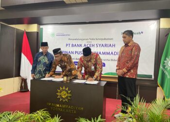 Ketua Pimpinan Pusat (PP) Muhammadiyah, Agung Danarto dan Plt Direktur Utama Bank Aceh, Fadhil Ilyas saat menandatangi Nota Kesepahaman (MoU). FOTO/Humas