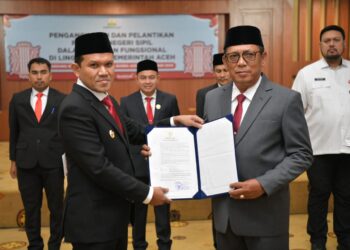 Wakil Gubernur Aceh, Fadhlullah, menyerahkan surat keputusan (SK) penunjukan Alhudri sebagai Pelaksana Tugas (Plt) Sekretaris Daerah Aceh menggantikan Muhammad Diwarsyah, di Gedung Serbaguna Kantor Gubernur Aceh, pada Rabu, (19/2/2025).
