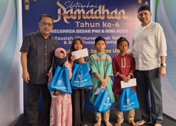 Ketua PWI Aceh, Nasir Nurdin (kiri) dan Kadiskominsa Aceh, Marwan Nusuf (kanan) foto bersama dengan anak yatim pada penyerahan santunan penggalangan PWI Aceh yang disalurkan pada rangkaian acara buka puasa bersama di PWI Aceh, Minggu, 23 Maret 2025. (Foto Abdul Hadi/PWI Aceh)