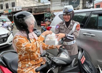 Personel Ditlantas Polda Aceh membagikan takjil kepada para pengendara yang melintas di sejumlah titik di Kota Banda Aceh, Senin, 10 Maret 2025.