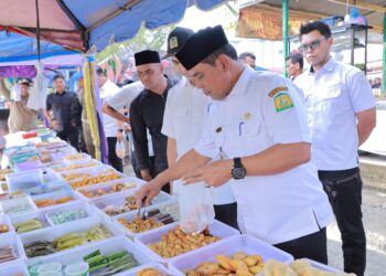 Bupati Aceh Besar, H Muharram Idris memilih dan membeli menu bukaan saat peninjauan penjualan takjil di Pasar Jantho, Aceh Besar, Rabu (5/3/2025) sore. FOTO/ PROKOPIM PEMKAB ACEH BESAR