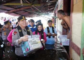 Kapolda Riau Irjen Mohammad Iqbal, didampingi Ketua Bhayangkari Daerah Riau Ny. Nindya Iqbal, memberikan bantuan sembako kepada warga yang terdampak banjir di Jalan Yos Sudarso, Rumbai, Kota Pekanbaru, pada Jumat (7/3/2025).