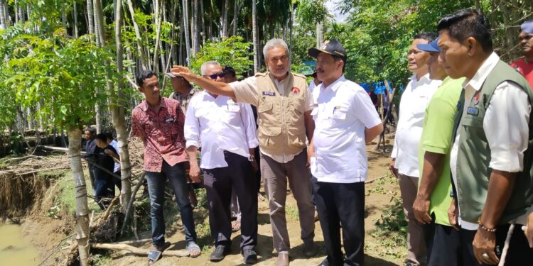 Wakil Bupati Aceh Besar Drs Syukri A Jalil di dampingi Staf Ahli Bupati Aceh Besar Ir Makmun MT Kepala Badan Kesbangpol Aceh Besar Sofian SH Kalaksa BPBD Aceh Besar Ridwan Jamil SSos MSi serta unsur personel dari Kompi B Batalyon 117KY meninjau lokasi banjir yang melanda Gampong Leungah Kecamatan Seulimeum Kabupaten Aceh Besar Selasa 3042025 FOTO DOK MC ACEH BESAR