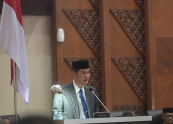 Plt Sekda Aceh M Nasir, menyampaikan laporan Gubernur tentang penetapan draft revisi Undang Undang Nomor 11 tahun 2006 atau UUPA, dalam rapat paripurna DPR Aceh, di Gedung UUPA, Rabu, (21/5/2025).