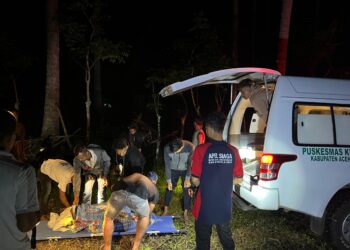 Petugas BPBD Aceh Besar Pos Lamteuba, bersama masyarakat mengevakuasi korban, di area perkebunan Gampong Lambada, Kemukiman Lamteuba, Kecamatan Seulimum, Kabupaten Aceh Besar, Senin (26/5/2025) malam. FOTO/ DOK BPBD ACEH BESAR