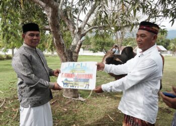 Bupati Aceh Besar H Muharram Idris (Syech Muharram) secara simbolis menyerahkan hewan qurban, di Masjid Agung Al-Munawwarah Kota Jantho, Aceh Besar, Jumat (6/6/2025). FOTO/ MC ACEH BESAR