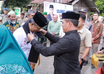 Bupati Aceh Besar H Muharram Idris (Syech Muharram) bersama Ketua TP PKK Kabupaten Aceh Besar Hj Rita Mayasari, menyambut tim penilaian lomba gampong tingkat Provinsi Aceh, di Beuradeun, Kecamatan Peukan Bada, Kabupaten Aceh Besar, Jumat (20/6/2025) pagi. FOTO/ PROKOPIM PEMKAB ACEH BESAR