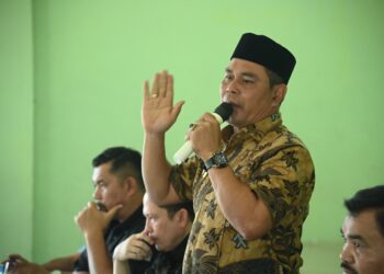 Bupati Aceh Besar H Muharram Idris menyampaikan sambutan saat penyerahan padi gogo jenis inpari 32 HDB kepada petani di 11 kecamatan di Aceh Besar, di Aula BPP Kuta Malaka, Kamis (26/6/2025). FOTO/MC ACEH BESAR