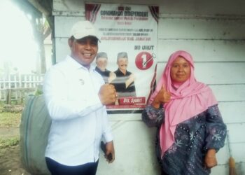 Bupati Aceh Besar, H Muharram Idris bersalam dengan simpatisannya Bu Tuti (58) saat meninjau pintu air di Cot Gue, Gampong Bung Pageu, Kecamatan Blang Bintang, Aceh Besar, Rabu (25/06/2025). FOTO/MC ACEH BESAR