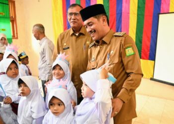 Wakil Bupati Aceh Besar Drs H Syukri A Jalil berbincang akrab dengan sejumlah murid baru Kelasa 1 di SDN Blang Bintang, Gampong Cot Mon Raya, Kecamatan Blang Bintang, Aceh Besar, Senin (14/07/2025). FOTO/MC ACEH BESAR