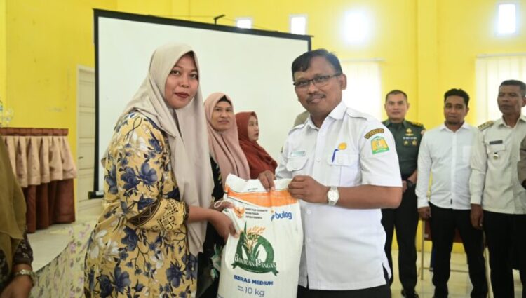 Kadis Pangan Aceh Besar Aliyadi SPi MM menyerahkan bantuan beras BPB secara simbolis kepada seorang penerima manfaat di Gedung UDKP Kecamatan Peukan Bada Kabupaten Aceh Besar Rabu 1672025 pagi FOTO MC ACEH BESAR