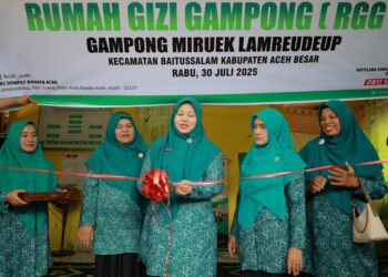 Ketua TP PKK Aceh Besar Hj Rita Mayasari, didampingi Wakil Ketua TP PKK Aceh Besar Nurul Fazli SAg, memotong pita sebagai simbolis peresmian RGG Miruek Lamreudeup, Kecamatan Baitussalam, Aceh Besar, Rabu (30/7/2025). FOTO/ MC ACEH BESAR