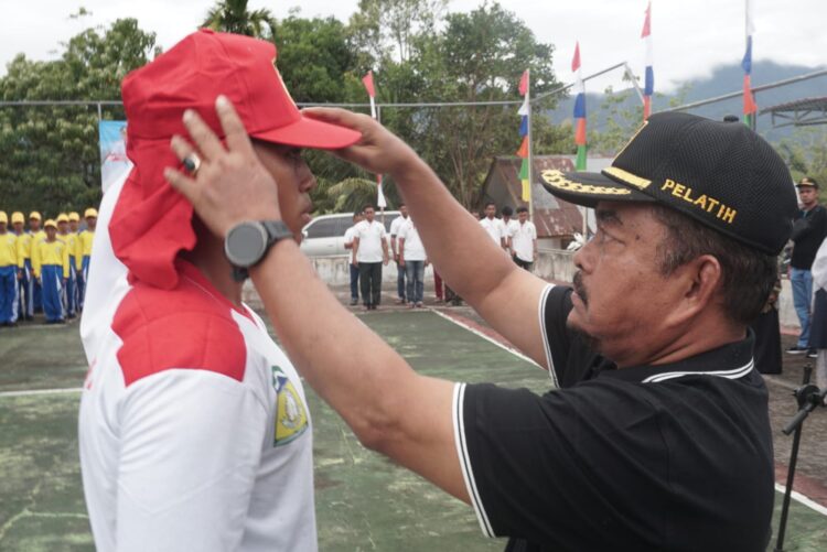 Asisten II Sekdakab Aceh Besar HM Ali SSos MSi memakaikan topi kepada Paskibra pada Upacara Pembukaan Diklat Petugas HUT RI Ke 80 di lapangan kantor Kesbangpol Kota Jantho Jumat 01082025 FOTOMC ACEH BESAR