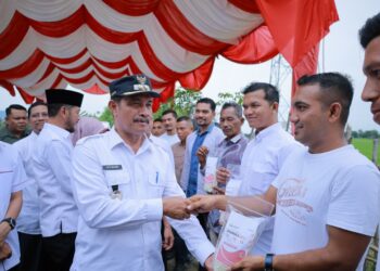 Wakil Bupati Aceh Besar Drs Syukri A Jalil menyerahkan pupuk bersubsidi jenis Urea dan NPK kepada Ketua BUMG , di Gampong Aneuk Glee, Indrapuri, Aceh Besar, Sabtu (16/8/2025). FOTO/MC ACEH BESAR