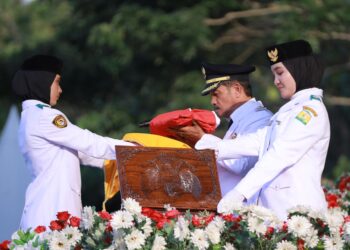 Drs Syukri A Jalil, menerima bendera saat penurunan Merah Putih Hari Ulang Tahun (HUT) ke-80 Kemerdekaan RI di Lapangan Bungoeng Jeumpa, Kota Jantho, Minggu (17/08/2025) sore. FOTO/PROKOPIM PEMKAB ACEH BESAR