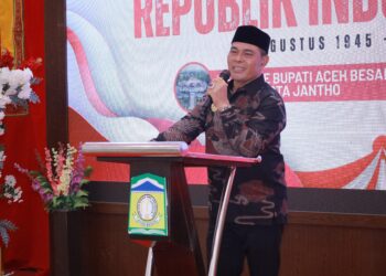 Bupati Aceh Besar H Muharram Idris, menyampaikan sambutan pada malam resepsi dan syukuran memperingati Hari Ulang Tahun (HUT) ke-80 Kemerdekaan Republik Indonesia yang digelar di Meuligoe Bupati Aceh Besar, Kota Jantho, Minggu (17/8/2025). FOTO/MC ACEH BESAR