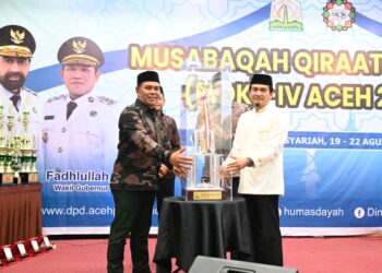 Bupati Aceh Besar H. Muharram Idris menerima piala bergilir juara umum pada penutupan MQK ke-IV Tingkat Provinsi Aceh Tahun 2025 di Hotel Grand Aceh Syariah, Lamdom, Banda Aceh, Kamis (21/8/2025) malam. FOTO/MC ACEH BESAR