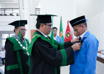 Rektor UIN Ar-Raniry, Prof Mujiburrahman didampingi Wakil Rektor III Prof Mursyid Djawas, memakaikan Almamater dan mengalungkan KTM sebagai tanda pengenal mahasiswa, pada PBAK 2025 dalam Rapat Senat Terbuka di Auditorium Prof Ali Hajsmy, Senin (25/8/2025). /Foto Humas Ar-Raniry