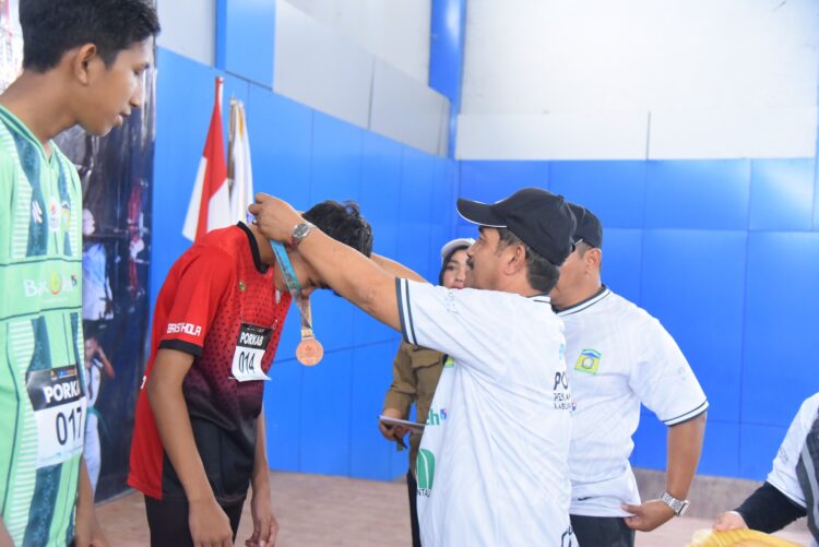 Wakil Bupati Aceh Besar Drs H Syukri A Jalil mengalungi medali dan menyerahkan piagam penghargaan kepada atlet olahraga atletik para peraih juara PORKAB Aceh Besar Tahun 2025 di Jantho Sport City JSC Selasa 992025 FOTOMC ACEH BESAR