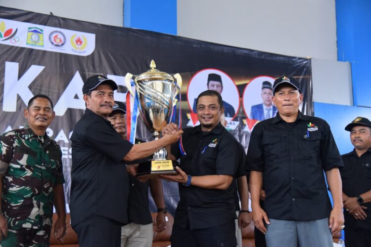 Wakil Bupati Aceh Besar Drs Syukri A Jalil meenyerahkan Piala Juara Umum PORKAB 2025 kepada Ketua Kontingen atau Camat Darul Imarah M Basir SSTP MSi di Jantho Sport City Kota Jantho Jumat 12092025 sore FOTOMC ACEH BESAR