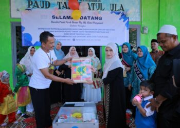 Ketua Pokja I Bunda PAUD Aceh Besar Hj Nurul Fazli SAg, menyerahkan alat belajar edukatif untuk anak-anak PAUD di Gampong Bira Lhok, Kecamatan Montasik, Kabupaten Aceh Besar, Selasa (16/9/2025). FOTO/ MC ACEH BESAR