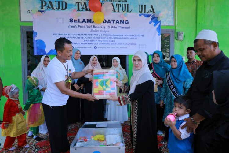 Ketua Pokja I Bunda PAUD Aceh Besar Hj Nurul Fazli SAg menyerahkan alat belajar edukatif untuk anak anak PAUD di Gampong Bira Lhok Kecamatan Montasik Kabupaten Aceh Besar Selasa 1692025 FOTO MC ACEH BESAR