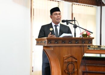 Bupati Aceh Besar, H Muharram Idris menyampaikan tanggapan terhadap rancangan Qanun tentang pengelolaan keuangan daerah dan rancangan Qanun tentang penyelenggaran cadangan pangan di Ruang Rapat Paripurna DPRK, Jumat (19/09/2025). FOTO/MC ACEH BESAR