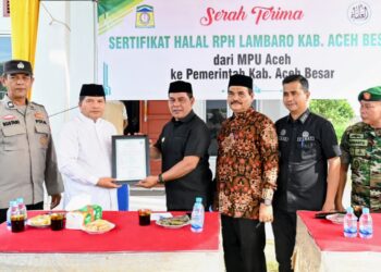 Bupati Aceh Besar, H Muharram Idris menerima Sertifikat Halal dari Ketua MPU Aceh Tgk H Faisal Ali dalam acara Launching Sertifikat Halal Rumah Potong Hewan Lambaro, Kecamatan Ingin Jaya, Aceh Besar, Jumat (31/101/2025). FOTO/MC ACEH BESAR