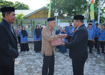 Sekretaris Daerah (Sekda) Kabupaten Aceh Besar, Bahrul Jamil, SSos, MSi, menyerahkan bingkisan kepada ahli waris saat ziarah ke Makam Panglima Teuku Nyak Makam di Gampong Lamnga, Aceh Besar, Minggu (9/11/2025). FOTO/MC ACEH BESAR