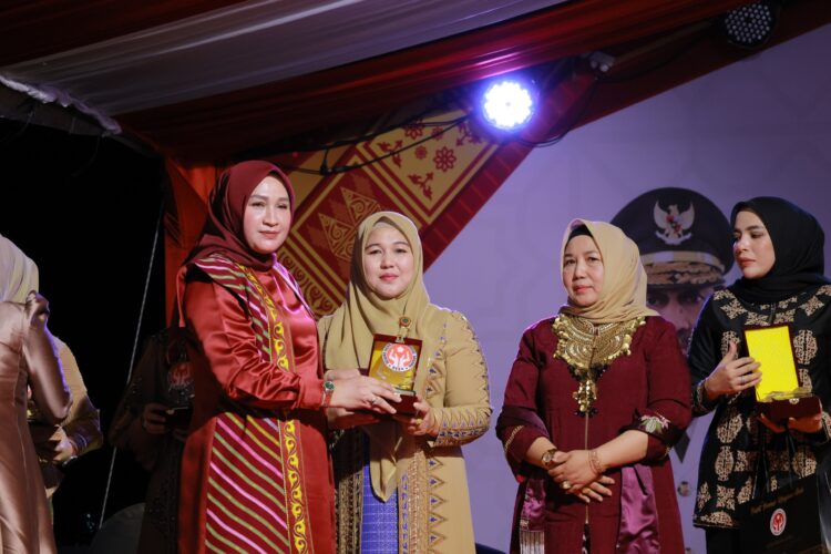 Ketua Dekranasda Aceh Besar Hj Rita Mayasari menerima plakat penghargaan dari Ketua Dekranasda Aceh Marlina Muzakir di Pasar Tani Lampineung Kecamatan Syiah Kuala Kota Banda Aceh Minggu 9112025 malam FOTO MC ACHE BESAR