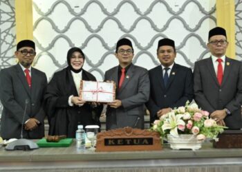Ketua DPRK Banda Aceh, Irwansyah, ST, menerima dokumen Raqan APBK Tahun 2026 dari Wali Kota Banda Aceh, Illiza Sa’aduddin Djamal disaksikan oleh Wakil Ketua I, Daniel Abdul Wahab, Wakil Ketua II, Dr. Musriadi, serta seluruh anggota DPRK Banda Aceh dalam rapat paripurna yang digelar di Lantai 4 Gedung DPRK Banda Aceh, Senin (10/11/2025).