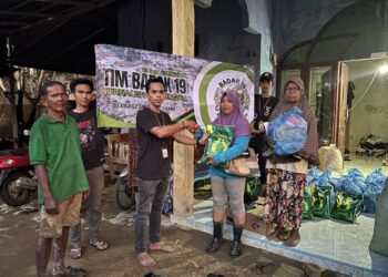 Koordinator Tim Badak-19, Mirza Inanda Putra R, menyerahkan paket bantuan logistik kepada warga korban bencana banjir di Kampung Durian, Aceh Tamiang pada Minggu 21/12/2025 (Foto: KETIKKABAR.com)