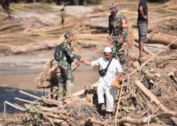 Prajurit Kodim 0111/Bireuen membantu warga meyebrangi sungai di Desa Cebrek, Bireuen, pada Senin, 1/12/2025