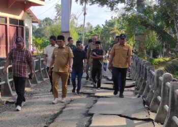 Bupati Aceh Besar, Muharram Idris didampingi Camat Blang Bintang, Subhan meninjau langsung lokasi jalan yang rusak akibat banjir di Gampong Teupin Batee, Kecamatan Blang Bintang, Senin (1/12/2025). FOTO/MC ACEH BESAR