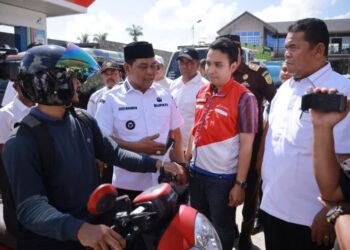 Bupati Aceh Besar H Muharram Idris (Syech Muharram), berdialog dengan masyarakat yang ikut mengantri BBM, di SPBU wilayah Aceh Besar, Rabu (3/12/2025). FOTO/ PROKOPIM PEMKAB ACEH BESAR