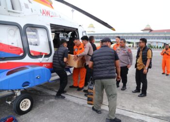 Personel Polda Aceh memuat bantuan logistik ke helikopter AW169 di Bandara SIM untuk dikirim kepada warga terdampak banjir di Aceh Tamiang, Jumat, 05/12/2025./FOTO: Humas Polda Aceh