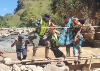 Personel Koramil 01Bandar Kodam Iskandar Muda saat mengevakuasi seorang warga An Ngadiman 70 seorang penduduk Desa Hakim Putri Pintu Kecamatan Mesidah yang membutuhkan pertolongan medis segera pada Minggu 07122025