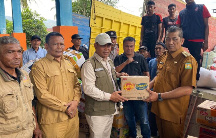 Bupati Aceh Besar H Muharram Idris Syech Muharram menerima bantuan dari Camat Seulimuem Devi Satria SE untuk korban banjir dan longsor yang melanda sejumlah kabupaten dan kota di Provinsi Aceh di Gudang Logistik BPBD Aceh Besar Kecamatan Sukamakmur Senin 8122025 FOTOMC ACEH BESAR