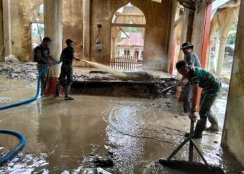 Prajurit TNI dari Kodim 0103/Aceh Utara bersama personel Brigif TP 90/Yudha Giri Dhanu, Kodam Iskandar Muda, karya bakti pembersihan Masjid Kampung Tanah Merah, Kecamatan Langkahan, Sabtu (13/12/2025).