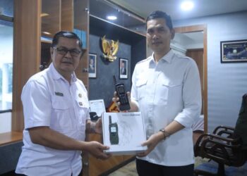 Kepala Diskominsa Aceh, Edi Yandra, menyerahkan 10 unit telepon satelit merek Iridium Extreme kepada Sekretaris Daerah (Sekda) Aceh, M. Nasir, di Banda Aceh, Rabu, 24 Desember 2025.