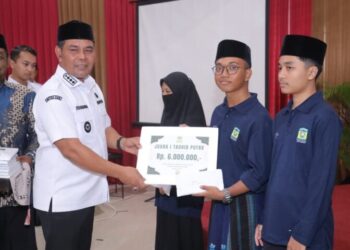 Bupati Aceh Besar H Muharram Idris menyerahkan bonus kepada kafilah MQK Aceh Besar, bertempat di Gedung Dekranasda Gampong Gani, Ingin Jaya, Rabu (31/12/2025). FOTO/MC ACEH BESAR