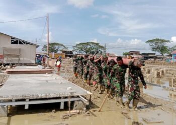 Personel dari Batalyon Infanteri (Yonif) 117/KY jajaran Kodam Iskandar Muda mengangkat tiang listrik untuk membantu pemasangan instalasi listrik bagi warga di Kecamatan Karang Baru, Kabupaten Aceh Tamiang, Rabu, 7 Januari 2026