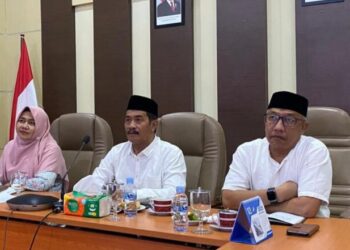 Wakil Bupati Aceh Besar Drs Syukri didampingi Asisten I Sekdakab Aceh Besar Farhan AP dan Kabag Pemerintahan Setdakab Aceh Besar Rahmadaniaty SSos MM mengikuti Rapat Koordinasi Pemulihan Pemerintahan dan Kemasyarakatan Pascamusibah banjir dan tanah longsor dengan Menteri Dalam Negeri Prof Tito Karnavian melalui zoom meeting, Jumat (9/1/2026). FOTO/ PROKOPIM PEMKAB ACEH BESAR