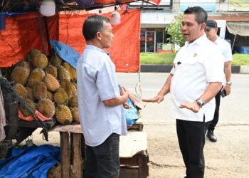 Bupati Aceh Besar, H Muharram Idris berdialog dengan pedagang buah durian saat tinjau para pedagang di pinggir jalan nasional depan MPP Lambaro, Kecamatan Ingin Jaya, Aceh Besar, Rabu (21/01/2026). FOTO/MC ACEH BESAR