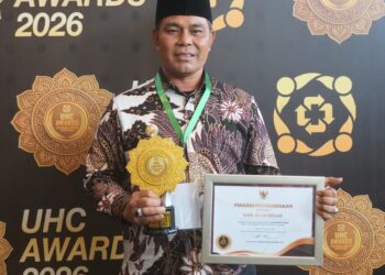 Bupati Aceh Besar H Muharram Idris (Syech Muharram) memperlihatkan perhargaan yang diraih acara penganugerahan UHC yang digelar di Jakarta International Expo (JIExpo) Kemayoran, Jakarta Pusat, Selasa (27/1/2026). FOTO/ PROKOPIM PEMKAB ACEH BESAR