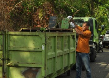 Kepala Bidang Pengelolaan Sampah dan Limbah B3 (PSLB3), Mulyadi SH, membantu proses pengangkutan sampah, di Aceh Besar, beberapa waktu lalu. FOTO/ MC ACEH BESAR