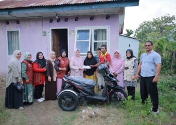 TP-PKK Aceh Besar, Hj. Rita Mayasari menyerahkan bantuan alat bantu fisik berupa satu unit sepeda motor roda tiga yang telah dimodifikasi kepada Musliadi M. Yusuf (46) penyandang disabilitas di Gampong Lam Manyang, Kecamatan Peukan Bada, Aceh Besar, Sabtu (14/02/2026) FOTO/ MC ACEH BESAR