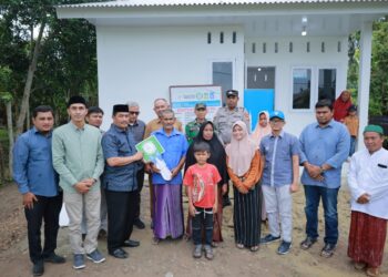 Wakil Bupati Aceh Besar Drs Syukri menyerahkan kunci rumah dhuafa berstruktur tahan gempa tipe 36 bantuan Islamic Relief Indonesia kepada penerima manfaat di Gampong Data Makmur Kecamatan Blang Bintang, Senin (16/02/2026). FOTO/MC ACEH BESAR