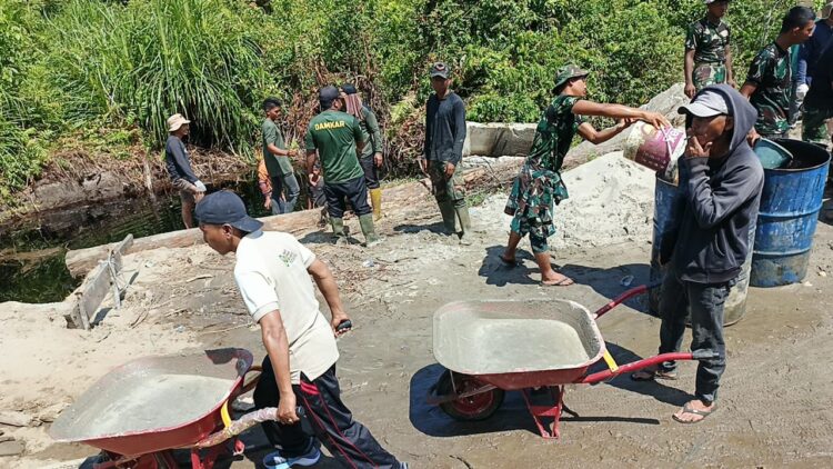 Personel TNI dari Kodim 0107Aceh Selatan bersama masyarakat Desa Raket bergotong royong mempercepat pembangunan jembatan Aramco di Kecamatan Trumon Kabupaten Aceh Selatan Rabu 2242026 KETIKKABARcom Personel TNI dari Kodim 0107Aceh Selatan bersama masyarakat Desa Raket bergotong royong mempercepat pembangunan jembatan Aramco di Kecamatan Trumon Kabupaten Aceh Selatan Rabu 2242026