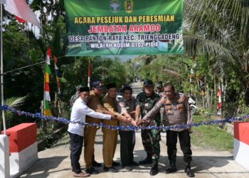 Pemotongan pita oleh unsur Muspika Kecamatan Trenggadeng atas Peresmian jembatan Aramco yang menghubungkan Desa Panton Raya dan Desa Tampui di Kecamatan Trenggadeng, Kabupaten Pidie Jaya, resmi kembali normal pada Senin (27/04/2026). [FOTO: KODAM IM]